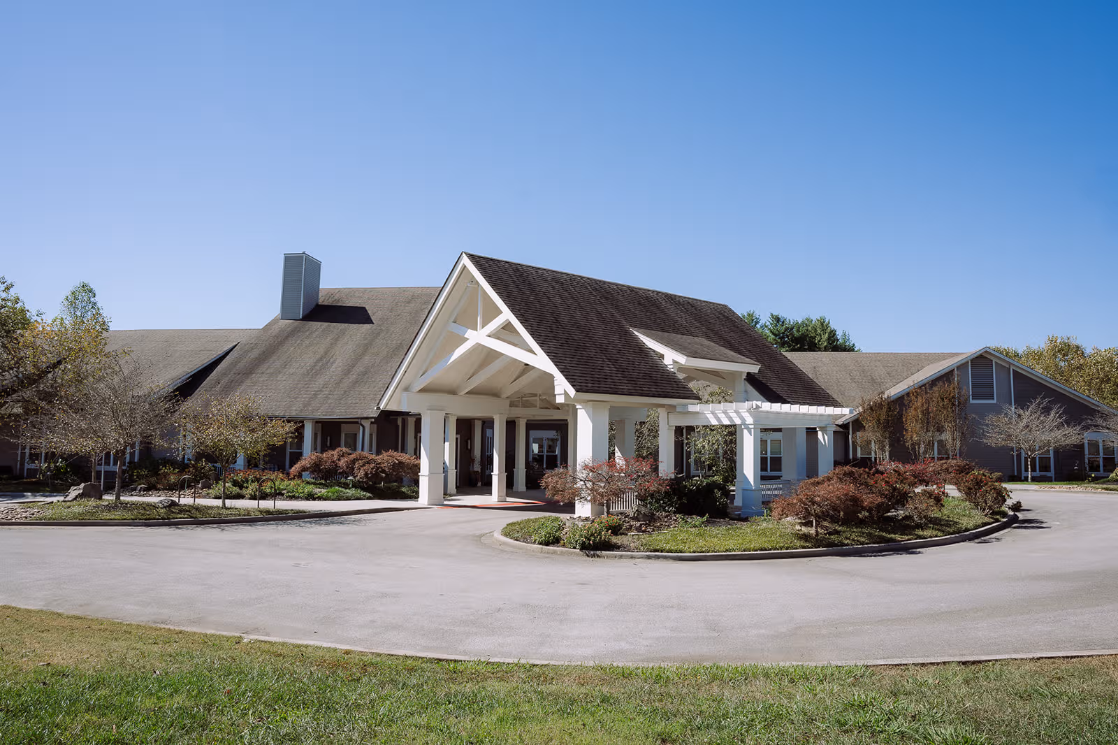 A single-story senior living facility with a welcoming front entrance and circular driveway.