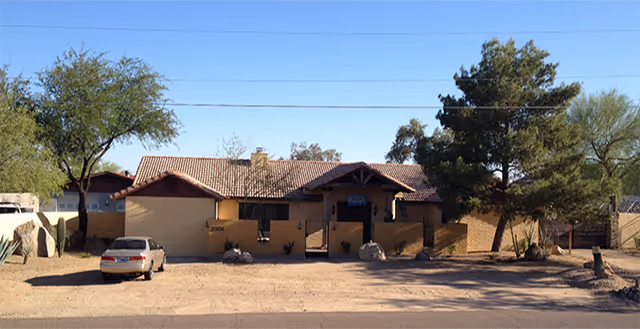 Front view of Mountain Cove Luxury Senior Care, a single-story beige house with a tiled roof.
