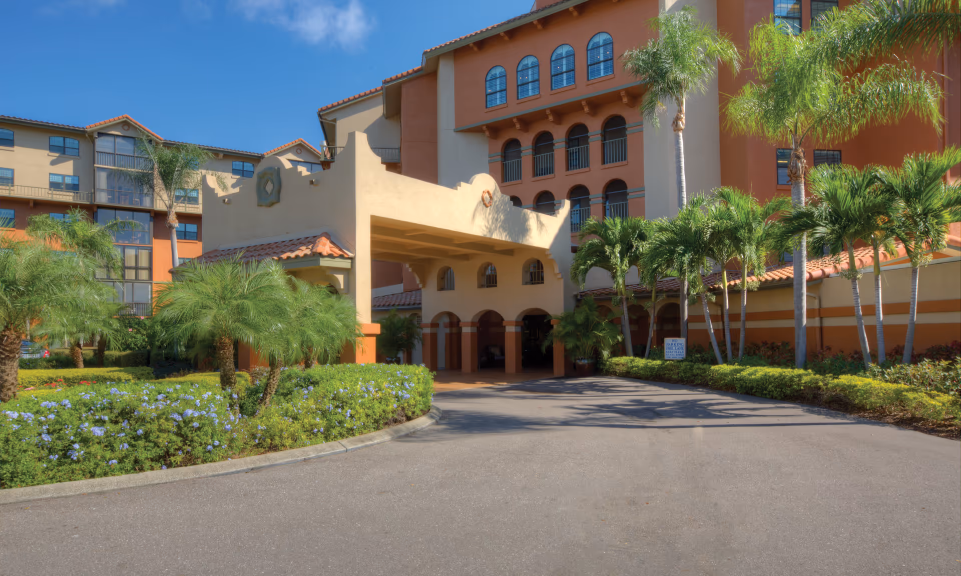 Exterior view of Lake Seminole Square with palm trees and arched entrance.