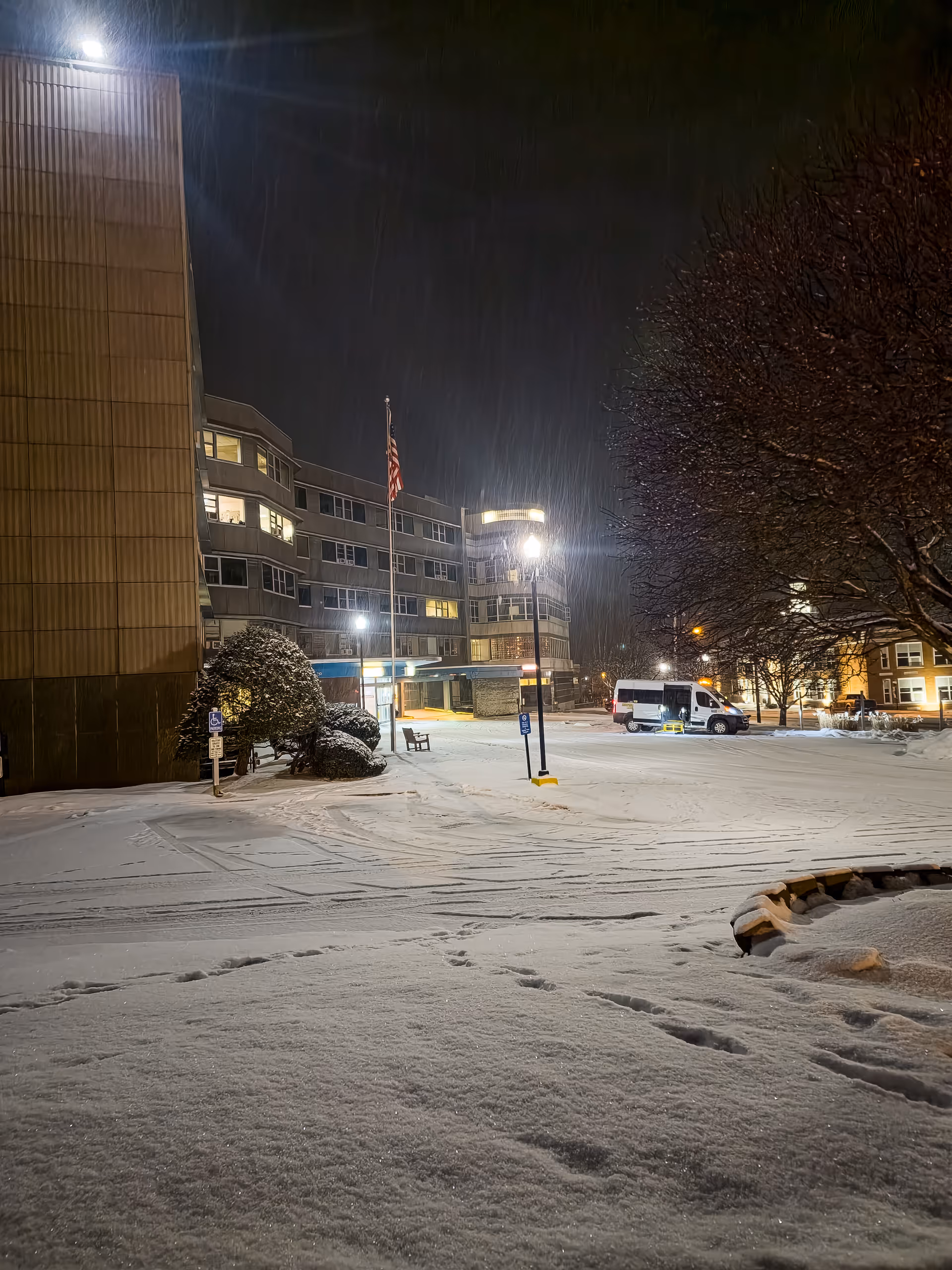Night exterior of Bradford Regional Medical Center with a snow-covered parking lot and a van.