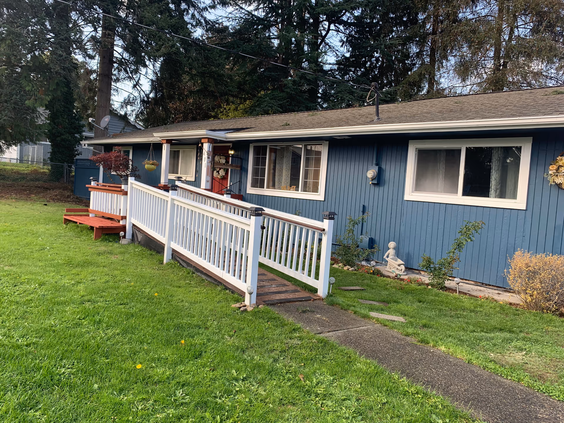 Blue single-story facility exterior with a ramp and white railing to the entrance.