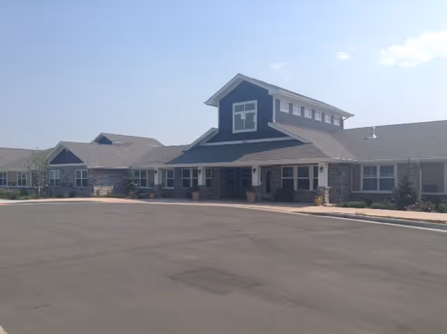 Exterior view of Greenridge Place senior living facility with a spacious parking lot.