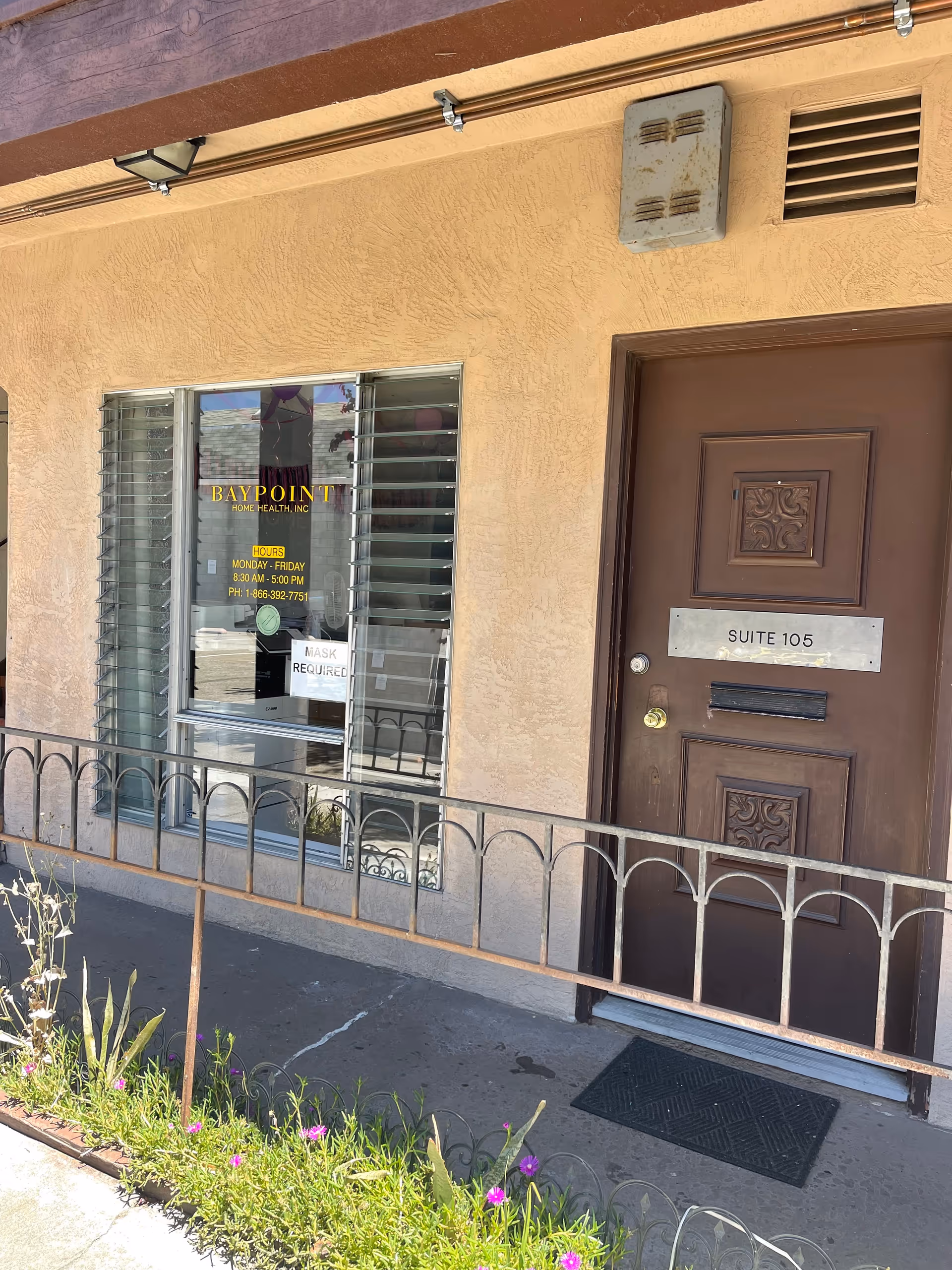 Exterior view of Baypoint Home Health storefront with a brown door and window signage.