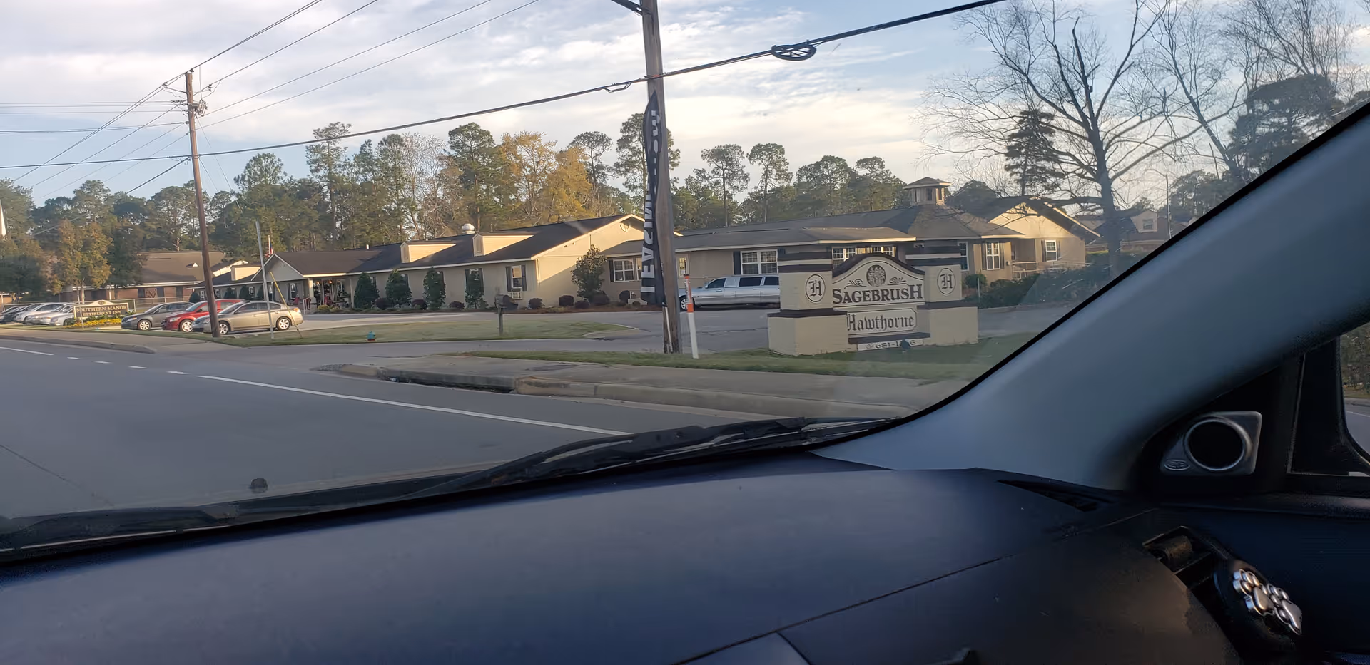 From inside a car, a senior living facility entrance and sign are visible along the street.