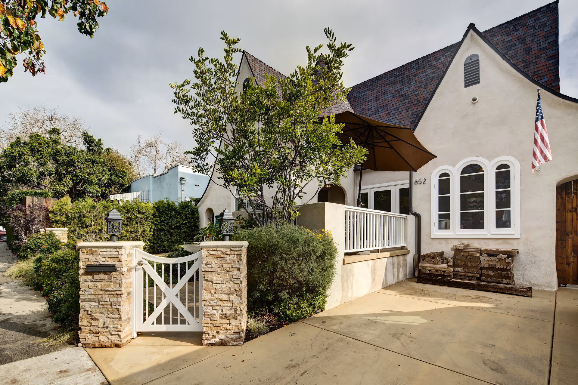 Exterior view of Raya's Paradise Inc. building with a gated stone entrance, arched windows, American flag.