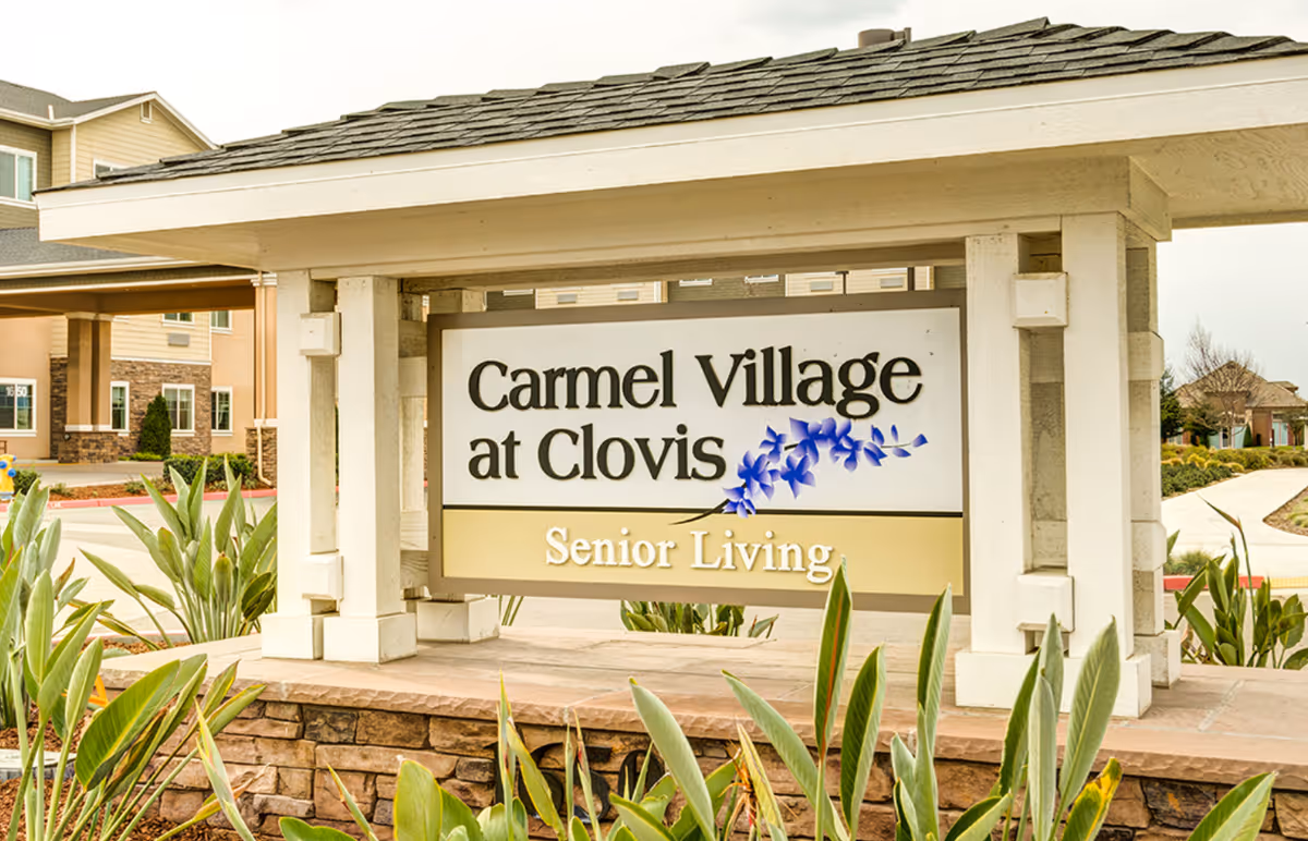 Exterior entrance featuring Carmel Village at Clovis Senior Living sign.