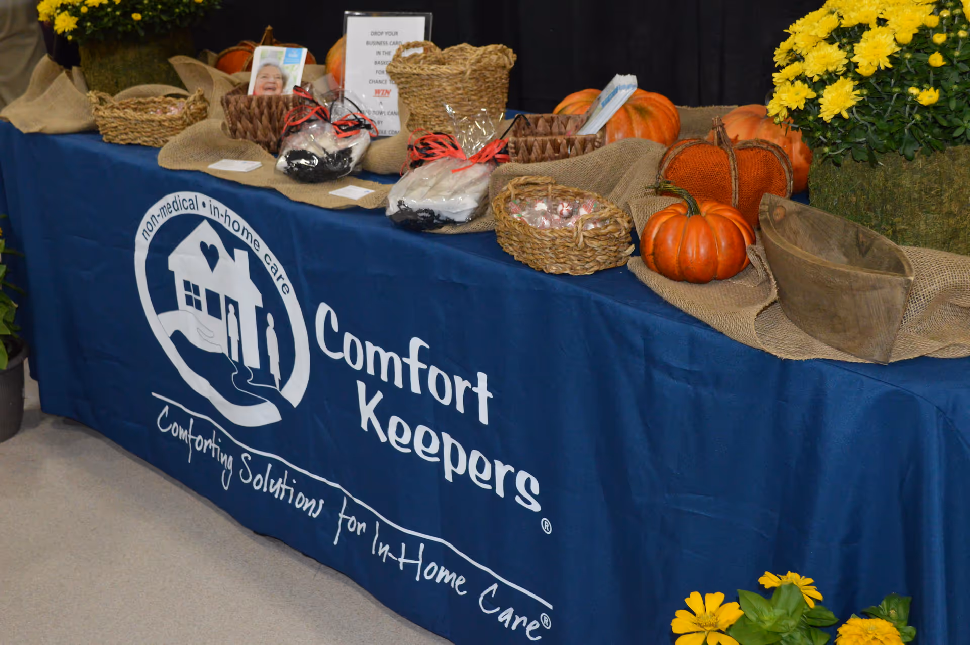 Blue Comfort Keepers table display with pumpkins and fall decorations at South Georgia facility.