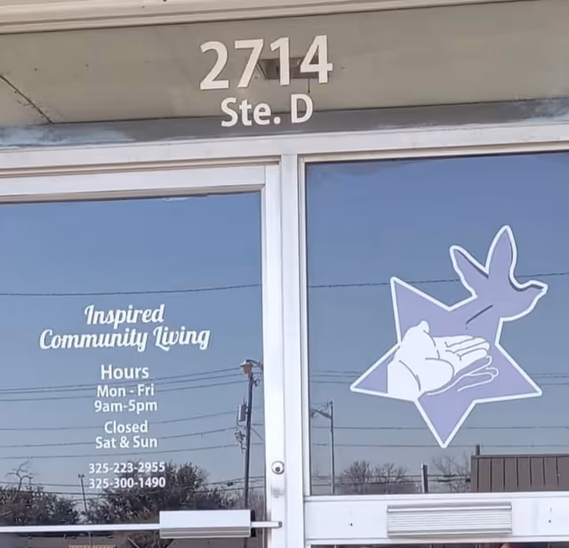 Glass doors display Inspired Community Living sign, hours, and logo at the building entrance.