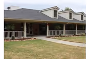 Front view of a single-story senior living facility with a covered porch.