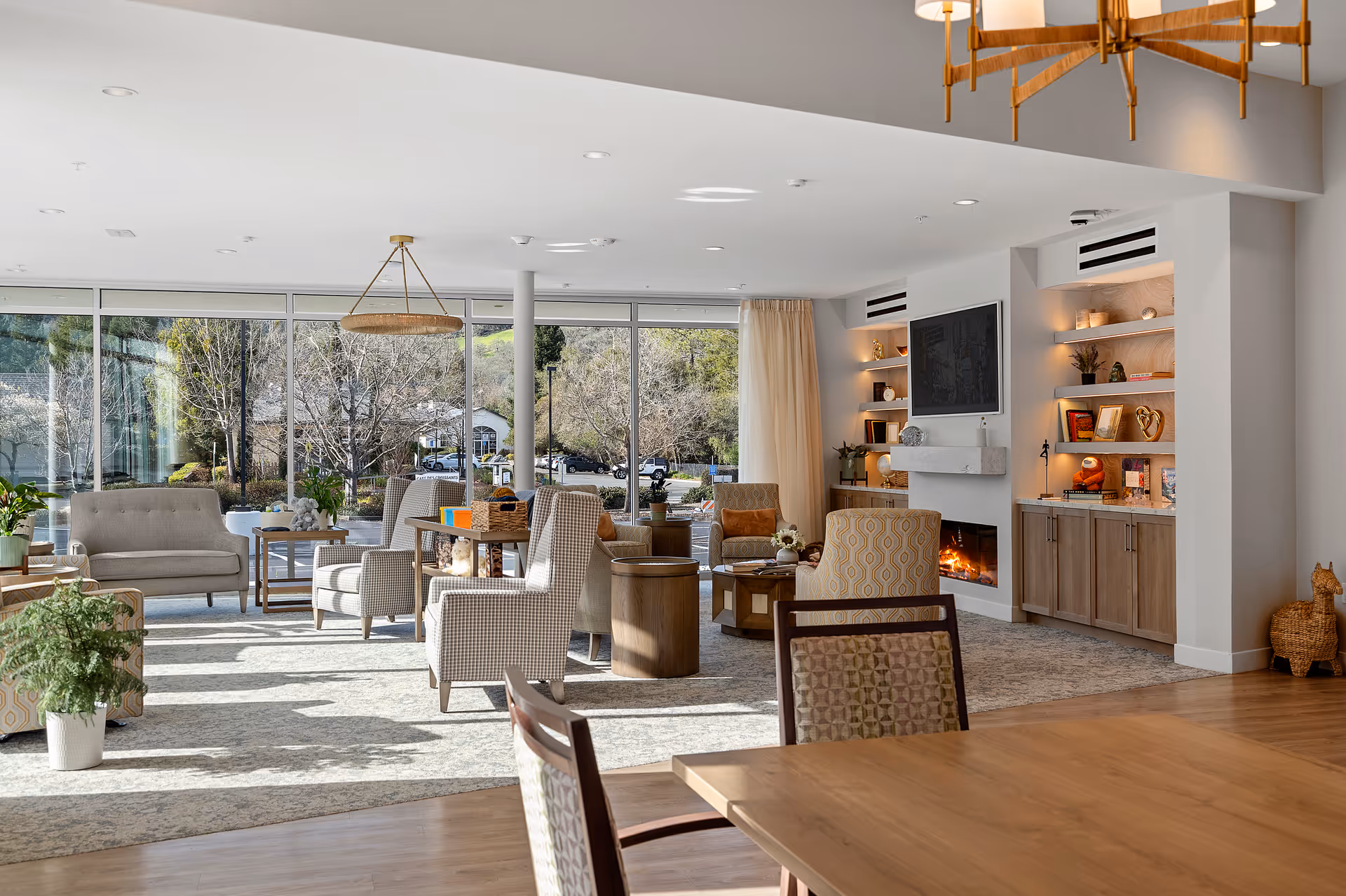 Bright, airy senior living lounge with sofas, fireplace, and built-in shelves.