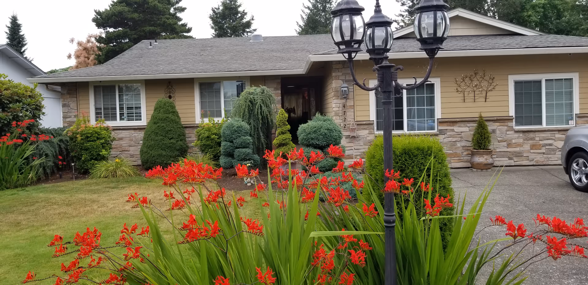 Front exterior of a single-story facility with landscaped yard and a three-lantern lamppost.
