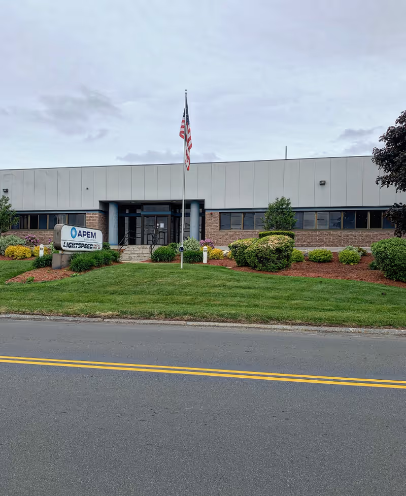 Front view of a single-story facility with a flagpole and manicured landscaping