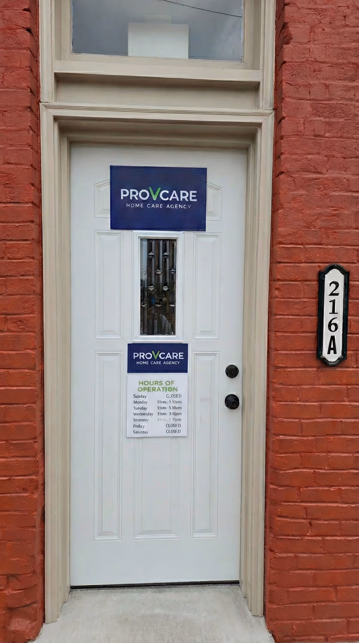 White front door with ProVCare signage on a red brick building exterior