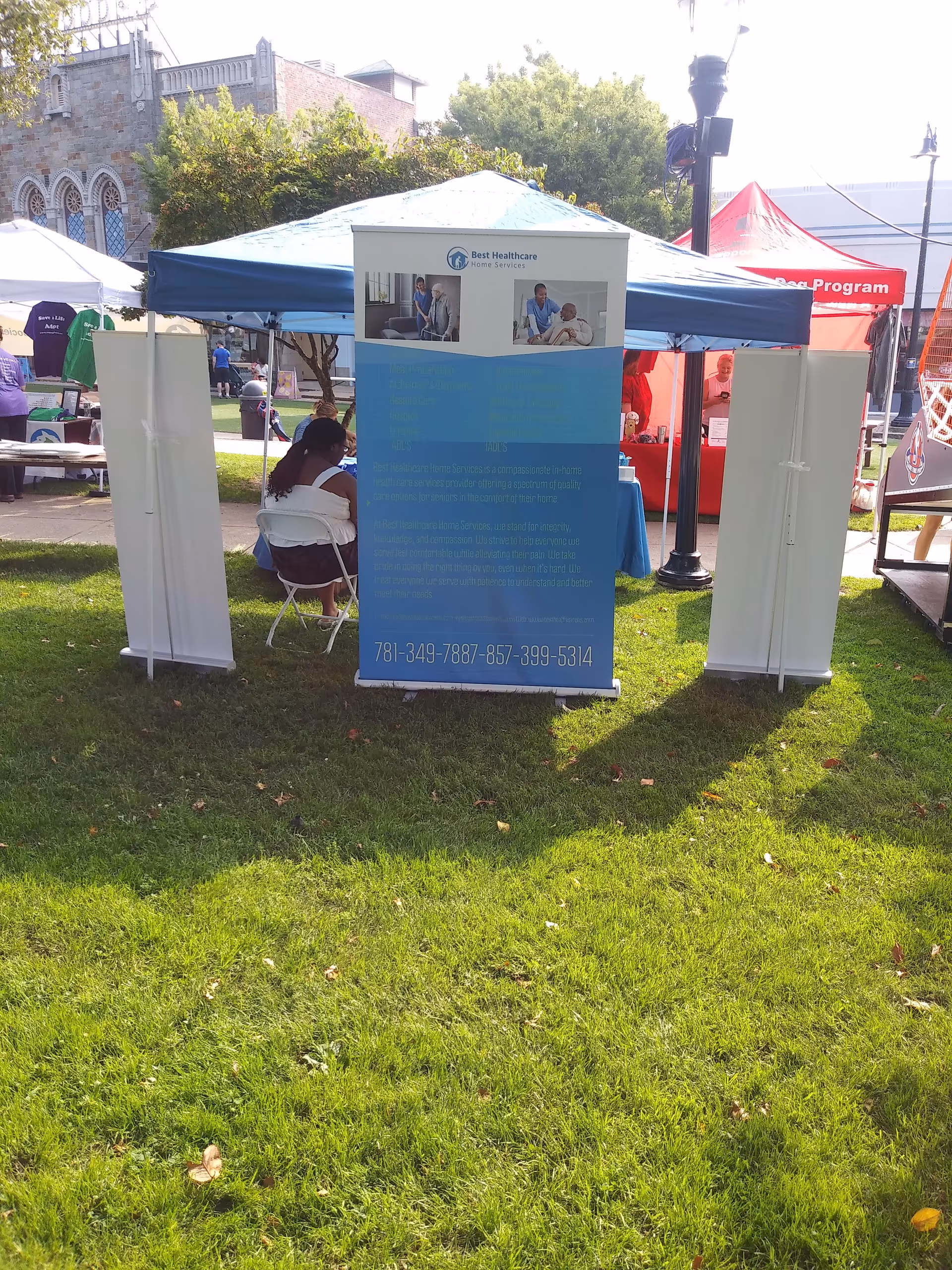 Outdoor booth for Best Healthcare Home Services at a community event with tents and banners.