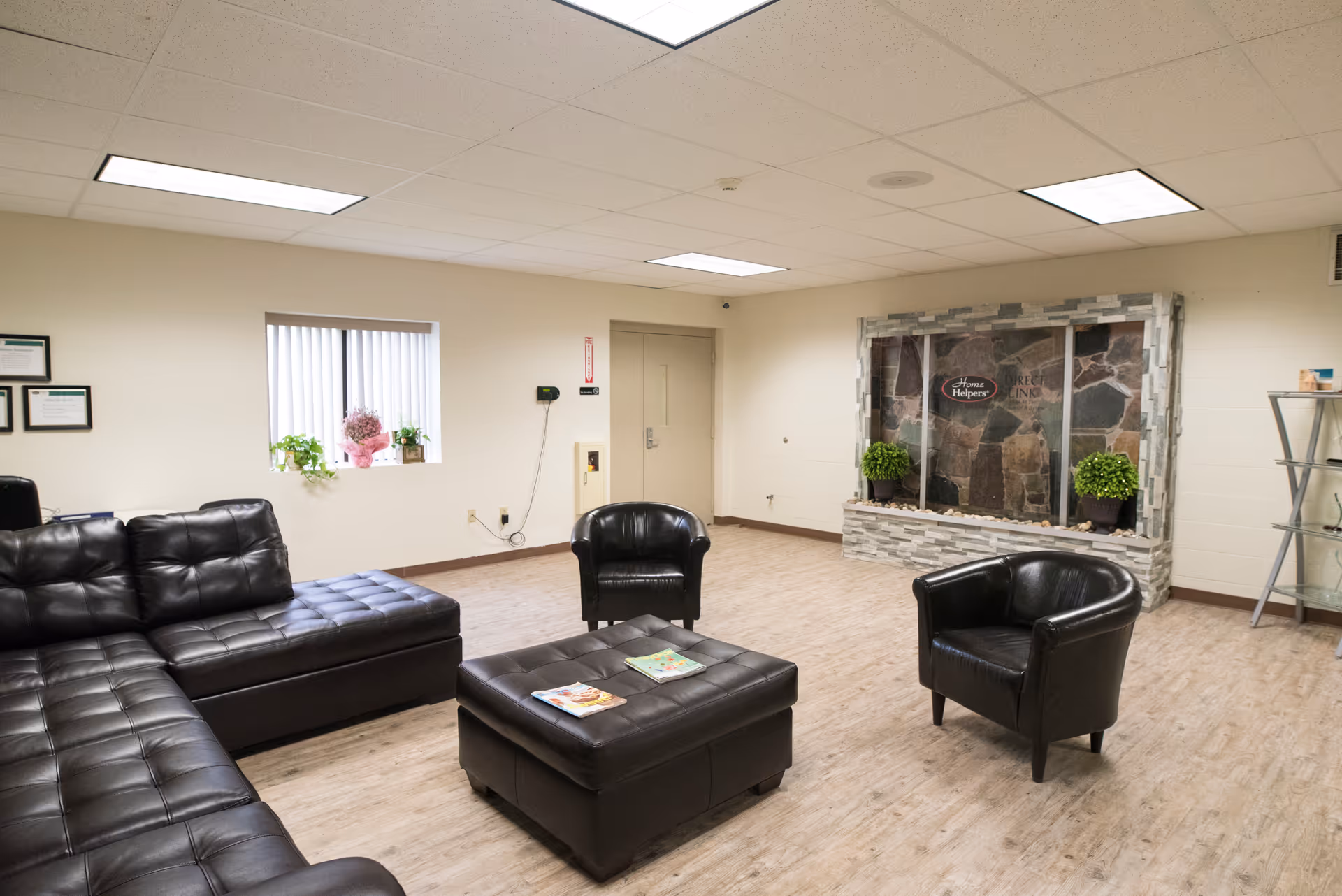 Lounge area with black leather seating and a stone-front fireplace.
