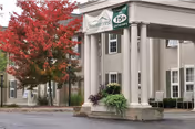 Exterior view of Summercrest Senior Living Community entrance with columns and red-leaf tree.