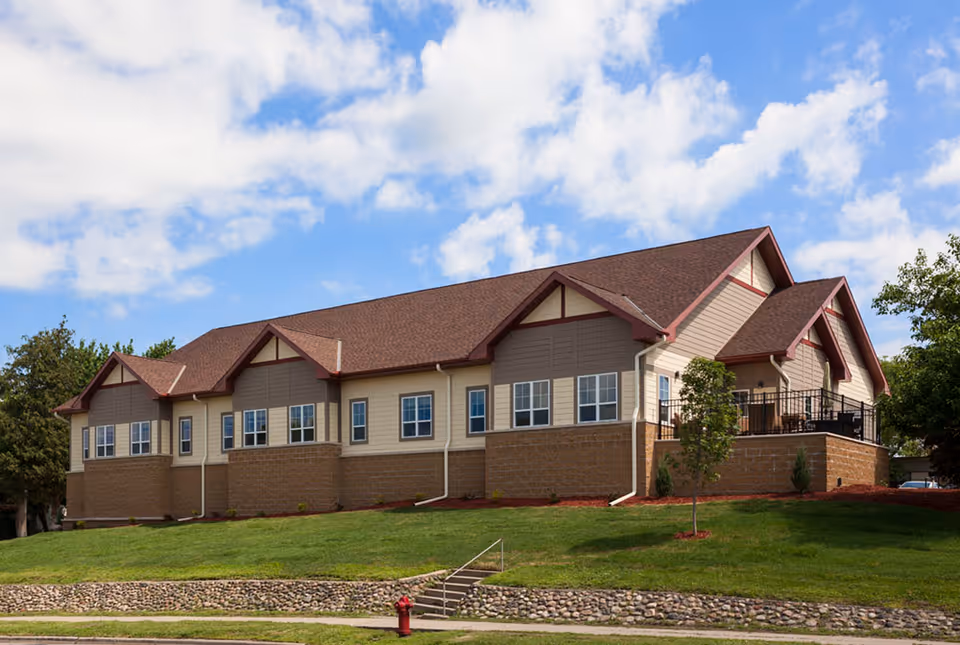 Exterior view of Lakeside Oasis senior living facility with a stone foundation and green lawn.