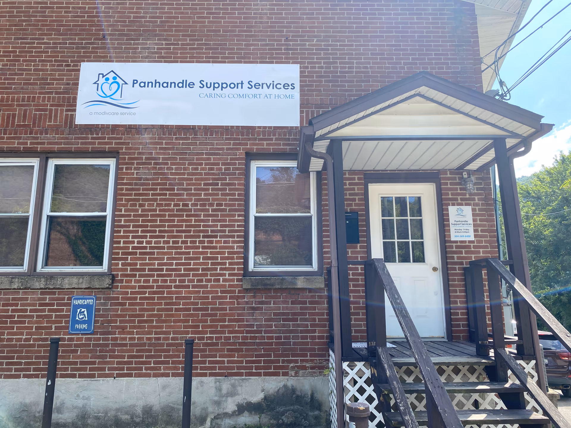 Brick building exterior with Panhandle Support Services sign and front porch.