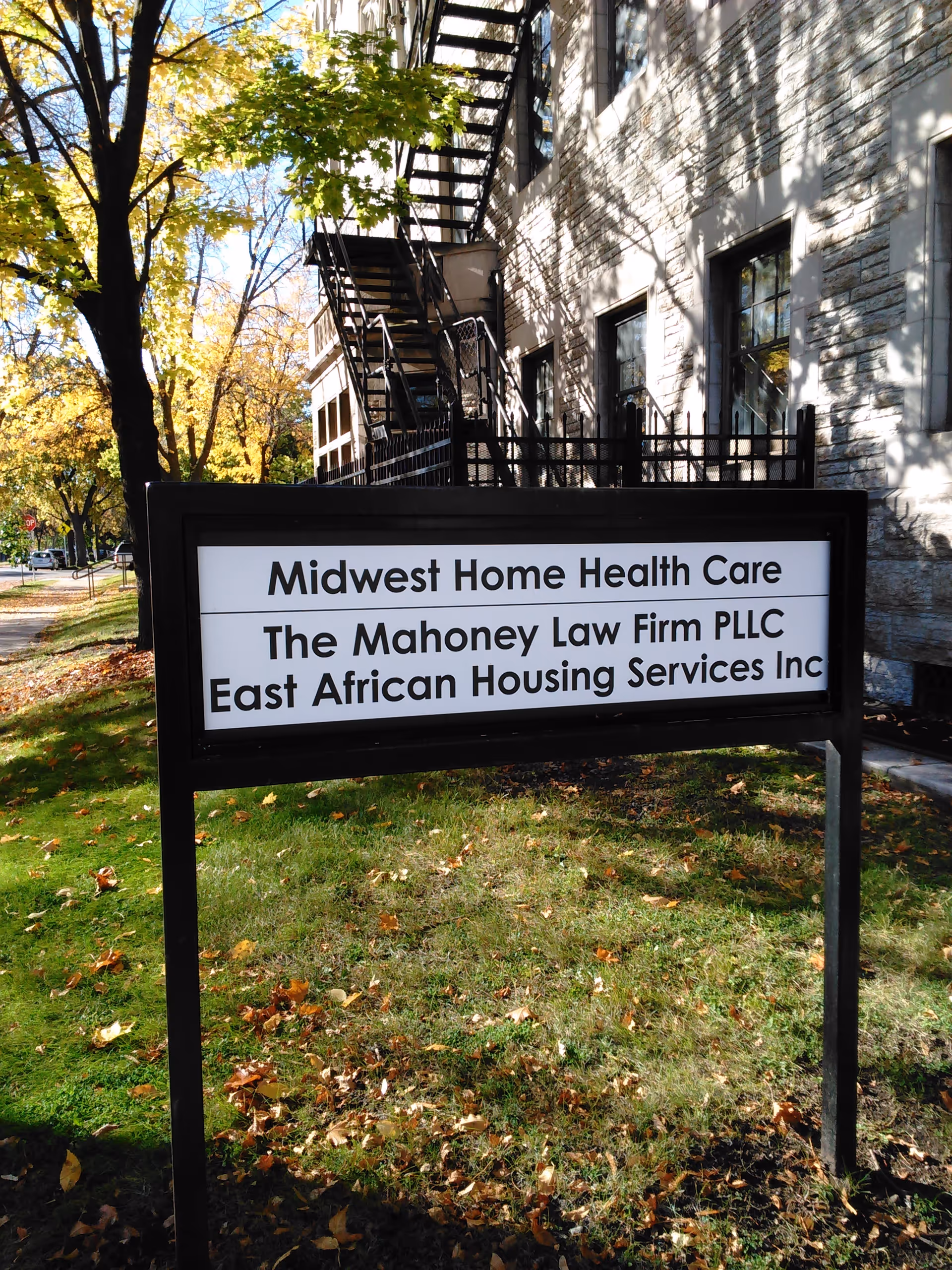 Sign in front of a building reading Midwest Home Health Care, with stairs and trees nearby.