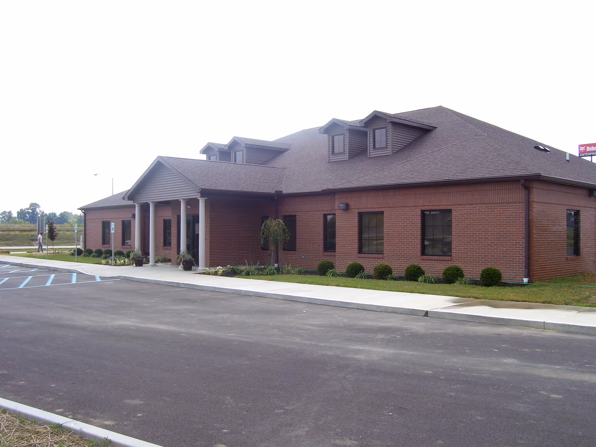 Brick, single-story Hospice of Hope building with a covered entrance and manicured landscaping.