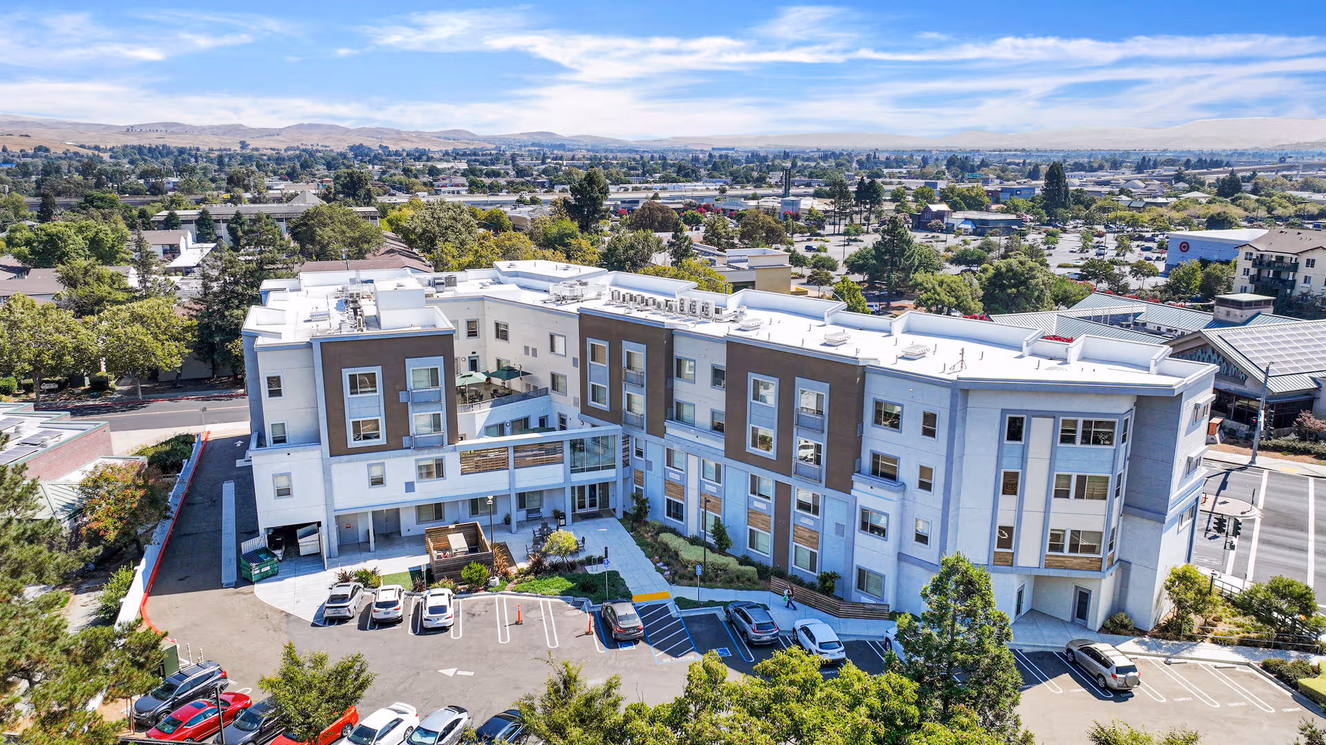 Aerial view of Emerald Care Home, a modern senior living building with parking.