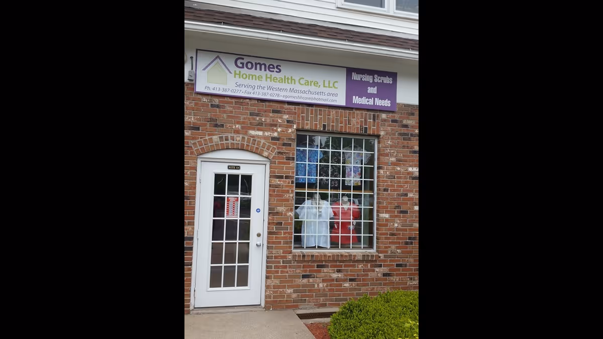Brick building front with a sign for Gomes Home Health Care LLC above a white door.