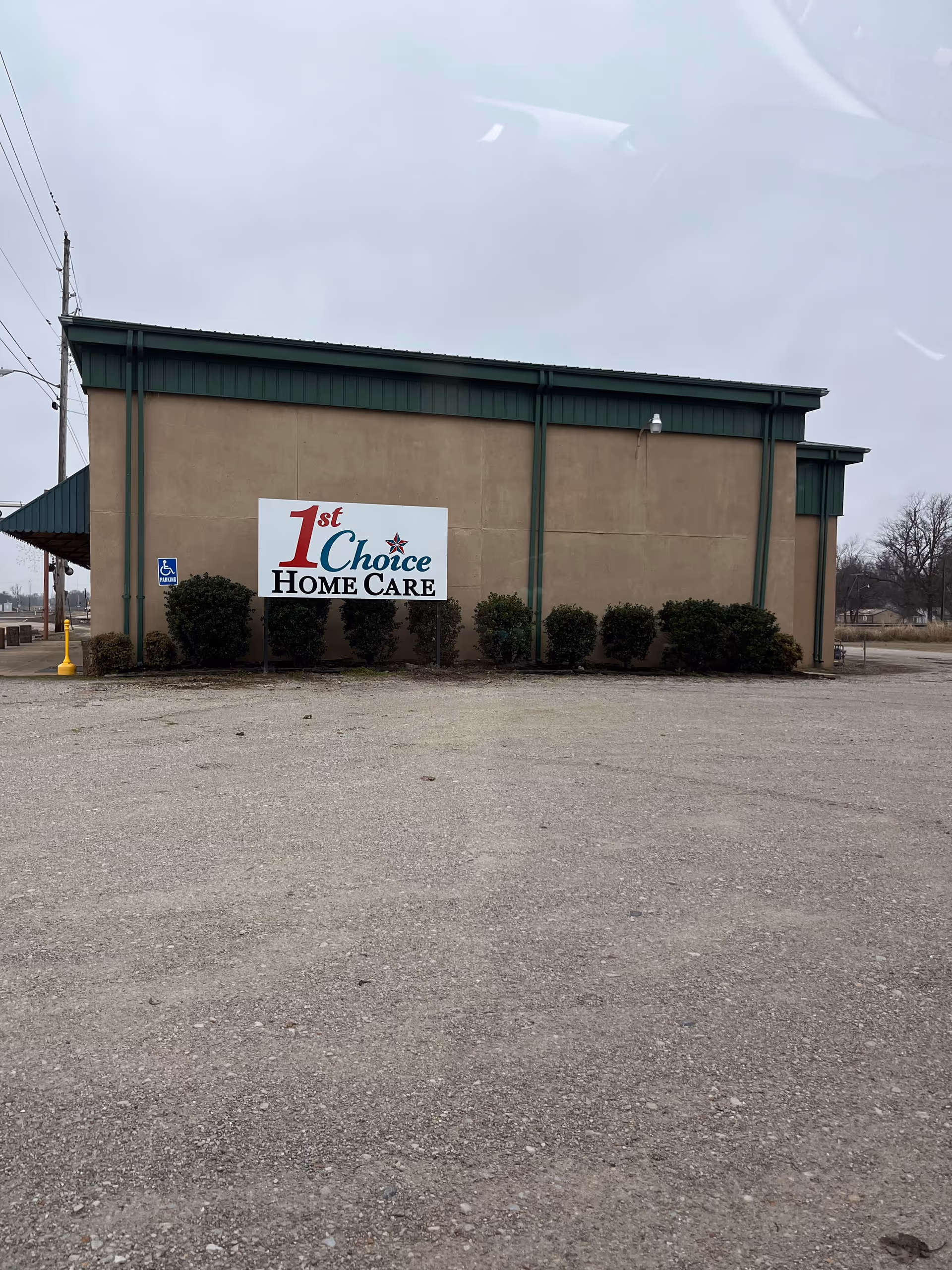 Exterior view of a beige building with green trim and a 1st Choice Home Care sign