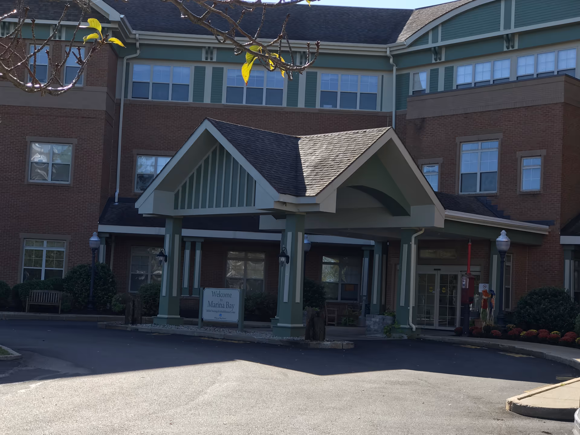 Front view of a senior living facility entrance with a covered porte-cochere.