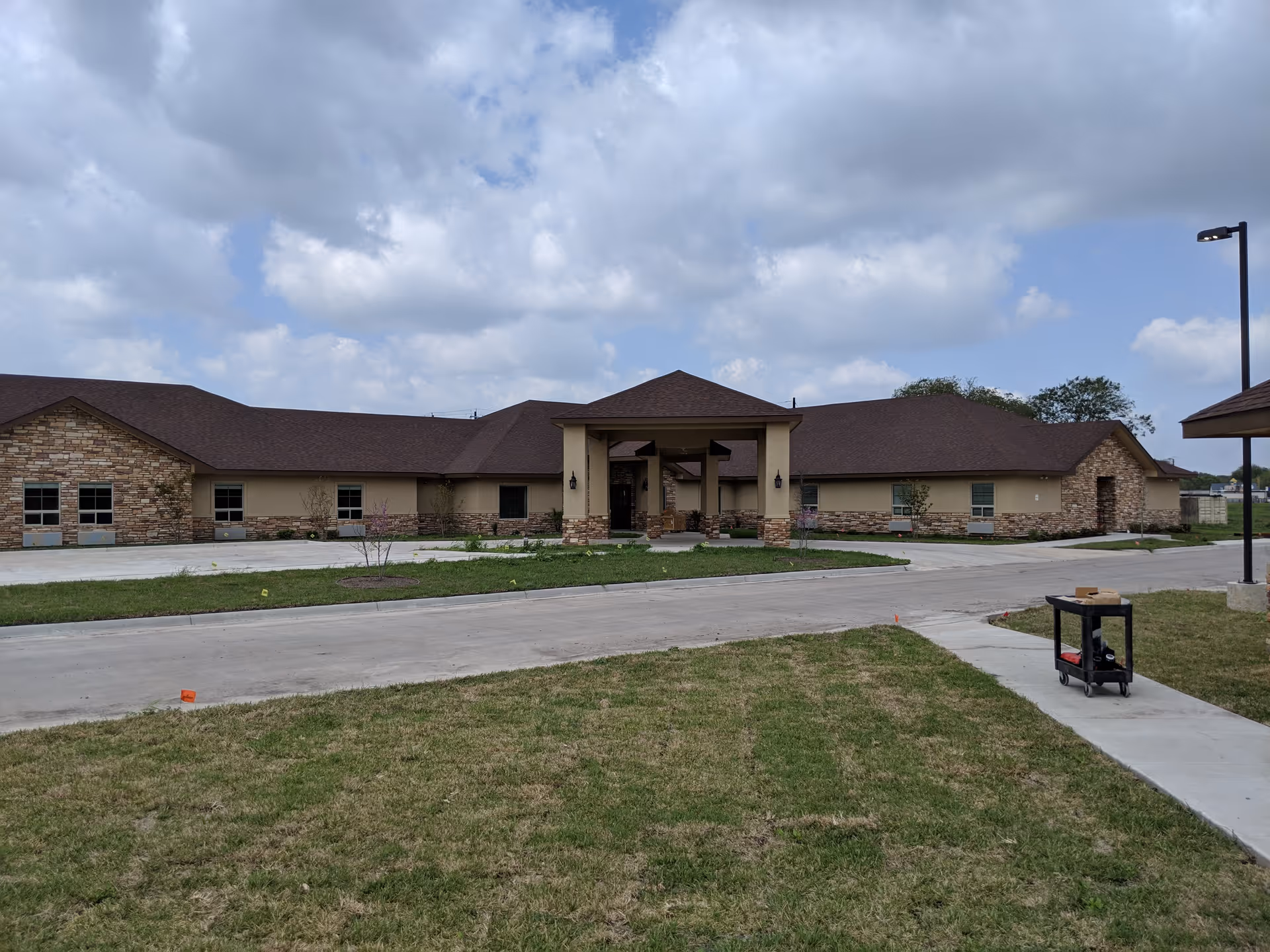 Exterior view of a single-story senior living facility with a central entrance.