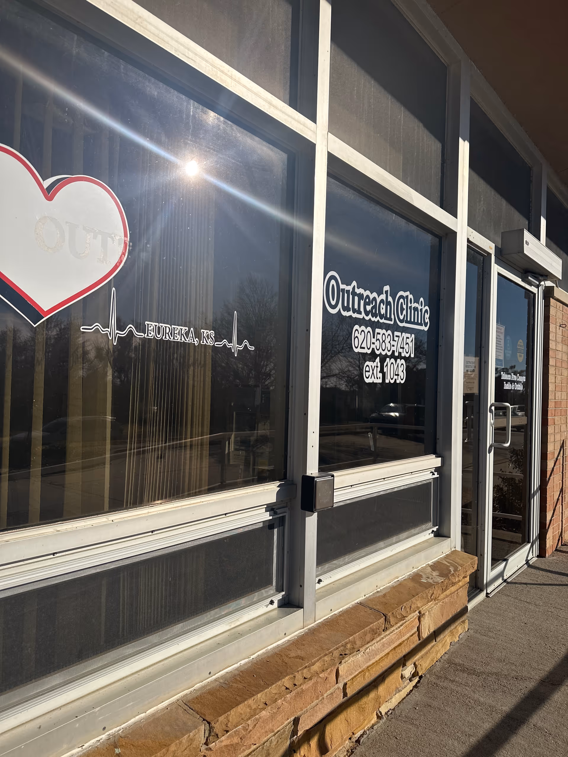 Exterior storefront with Outreach Clinic signage and heart logo on glass windows