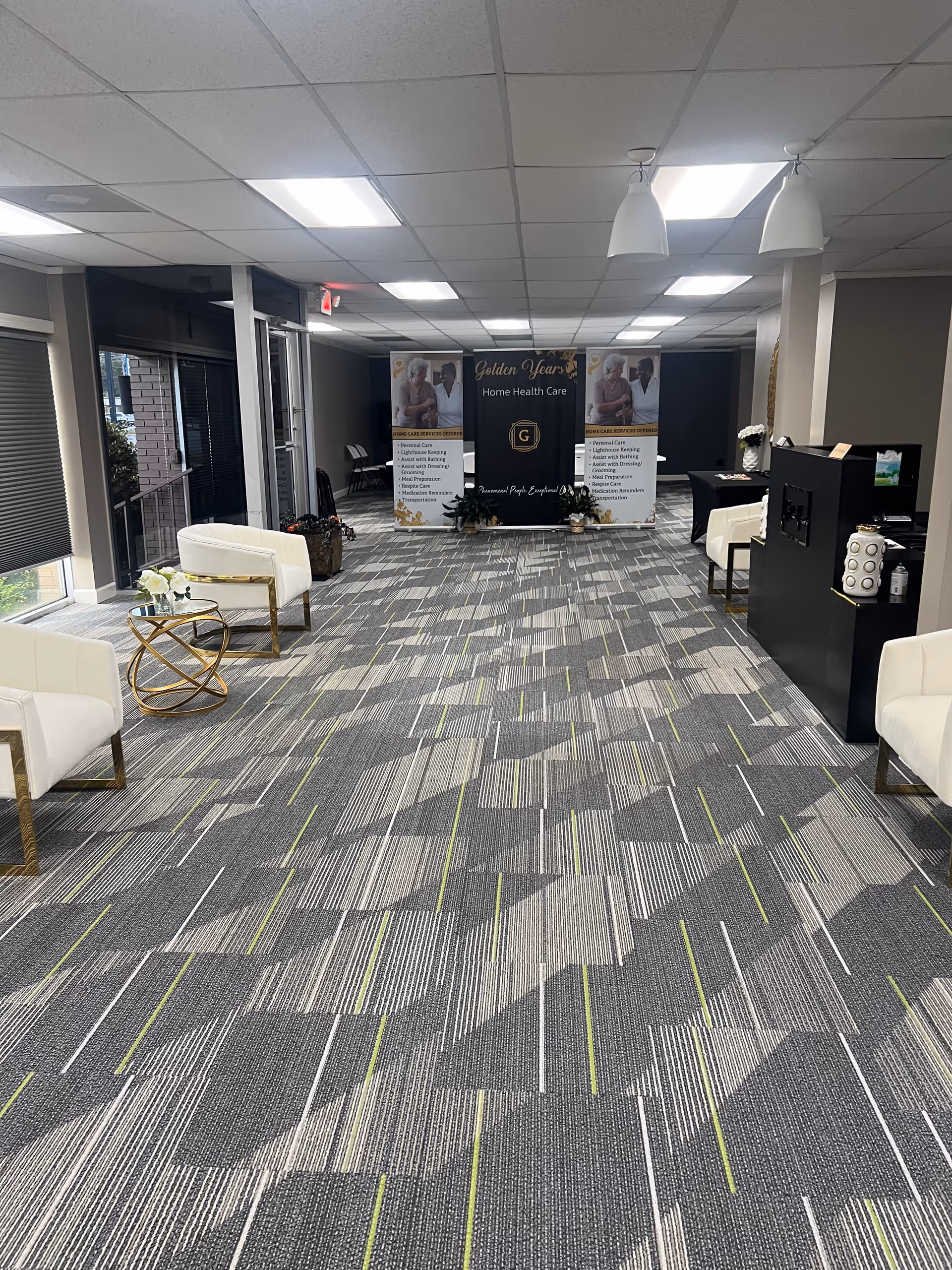 Lobby area with white chairs and banners for Golden Years Home Health Care inside a facility.