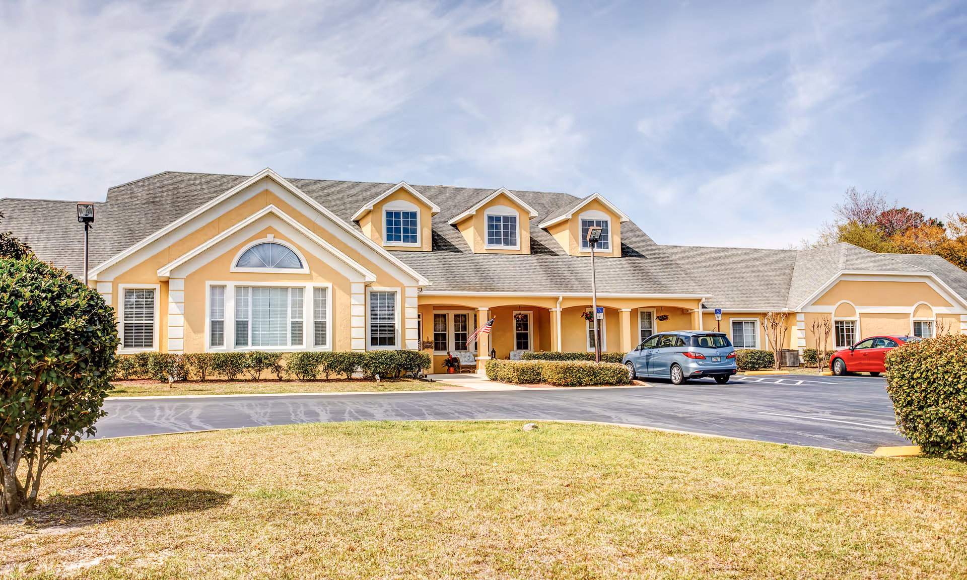 Exterior view of a Brookdale Panama City senior living facility with parked cars.