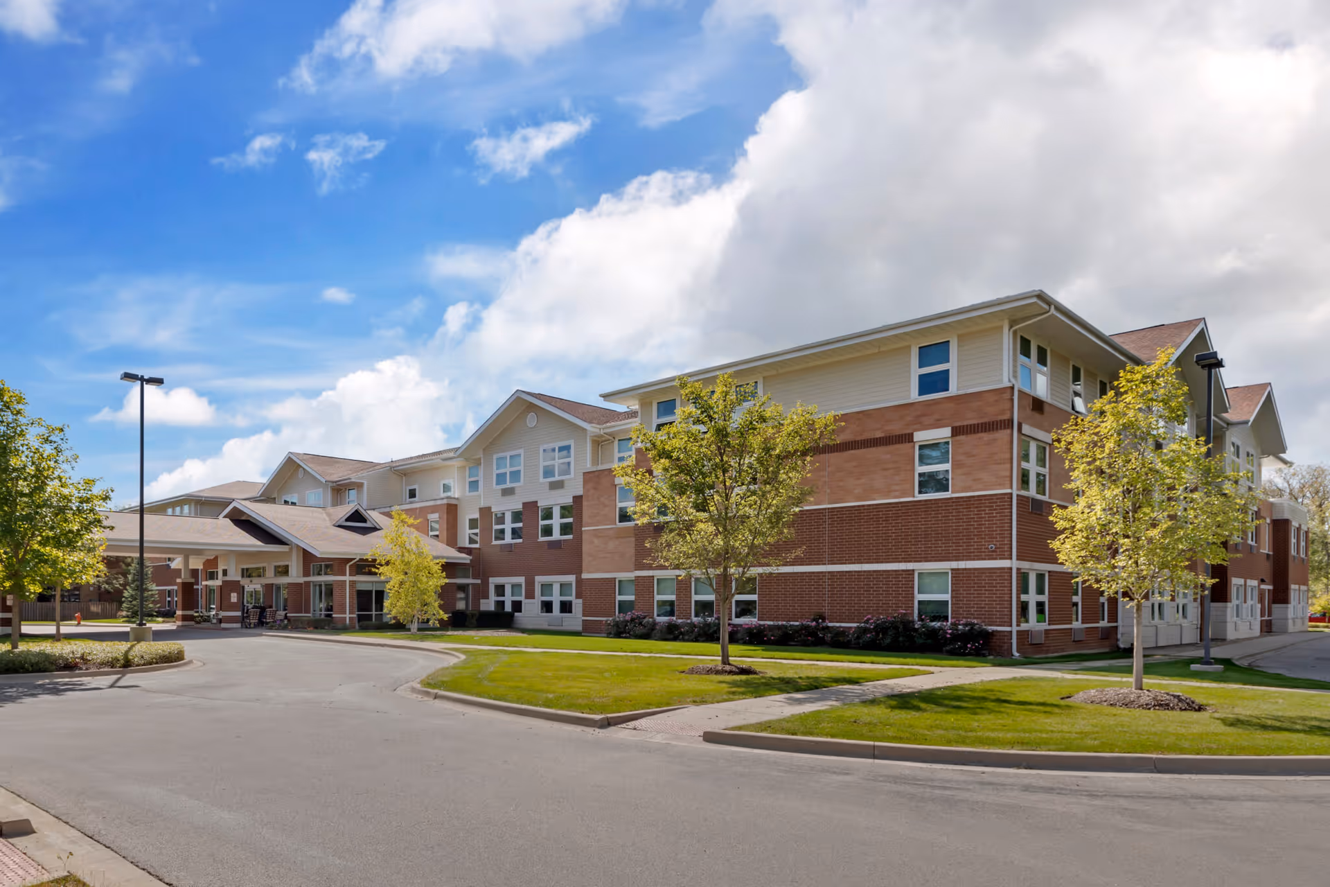 Exterior view of The Sheridan at Tyler Creek, brick building with trees and driveway.