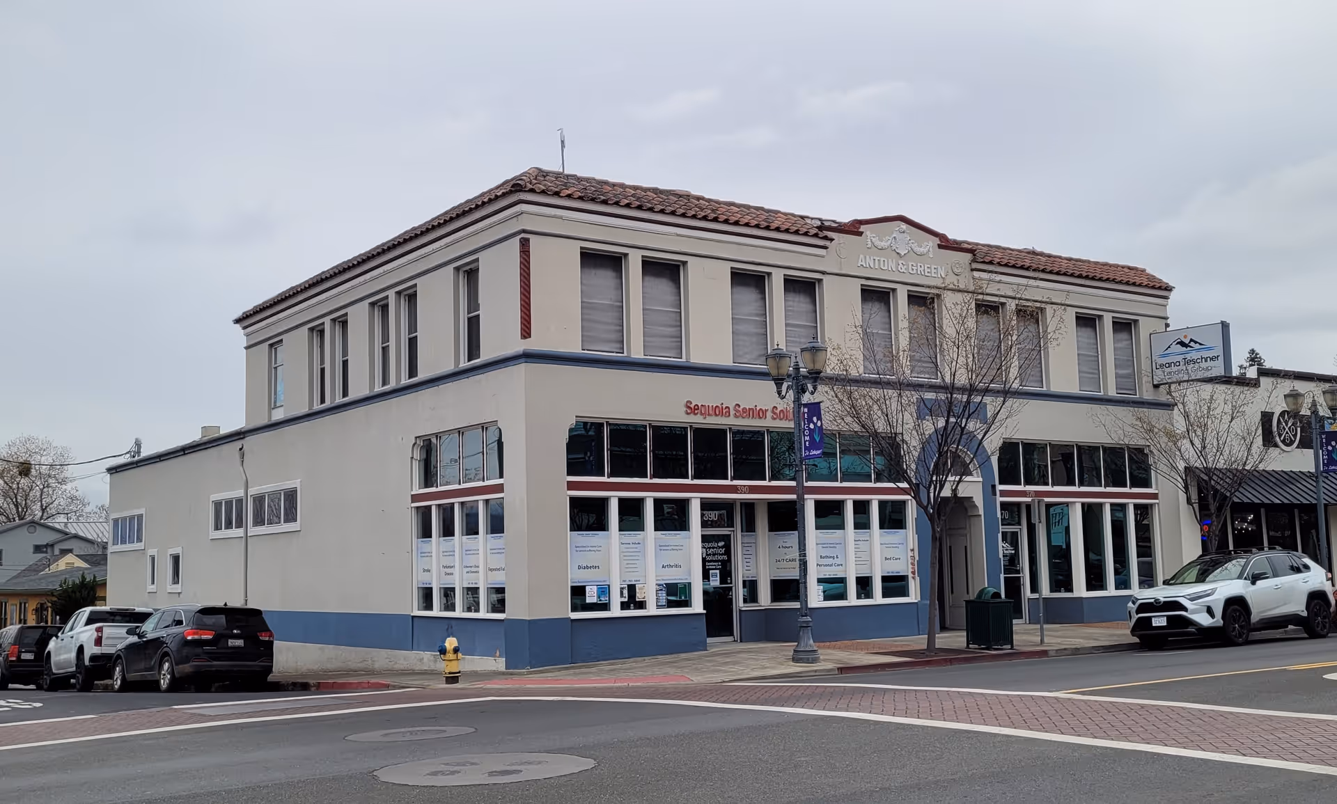 Exterior view of a two-story building with Sequoia Senior Solutions sign and cars.