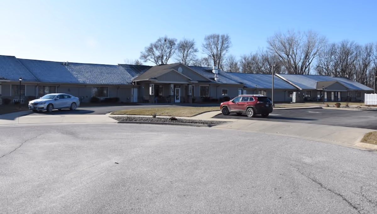 Exterior view of Cedar Vale Assisted Living facility with parked cars in front.