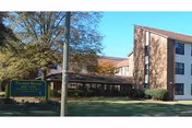 Exterior view of Tucker House senior living facility with sign and entrance.