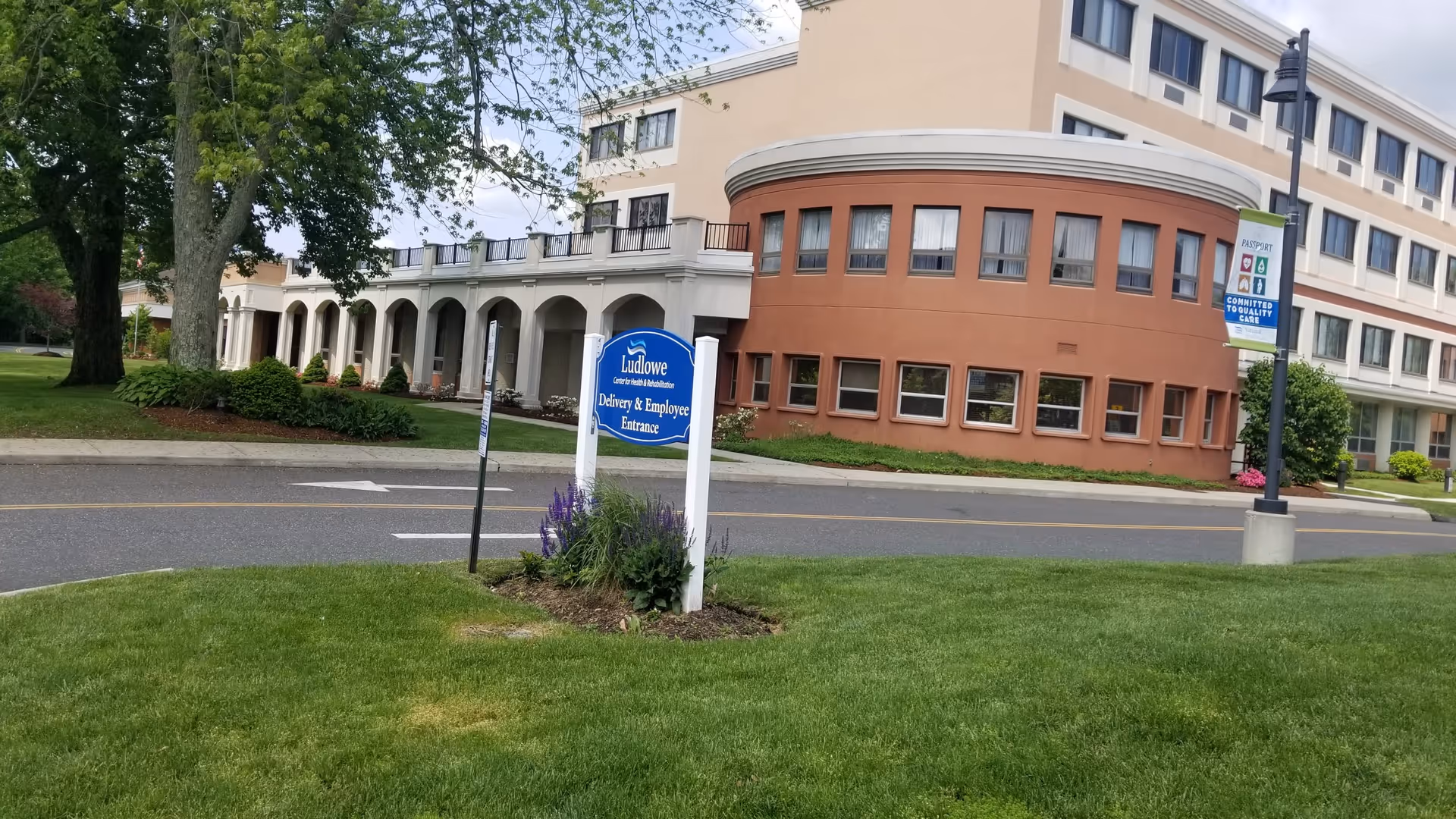 Exterior view of Ludlowe Center building with curved brick facade and lawn sign.