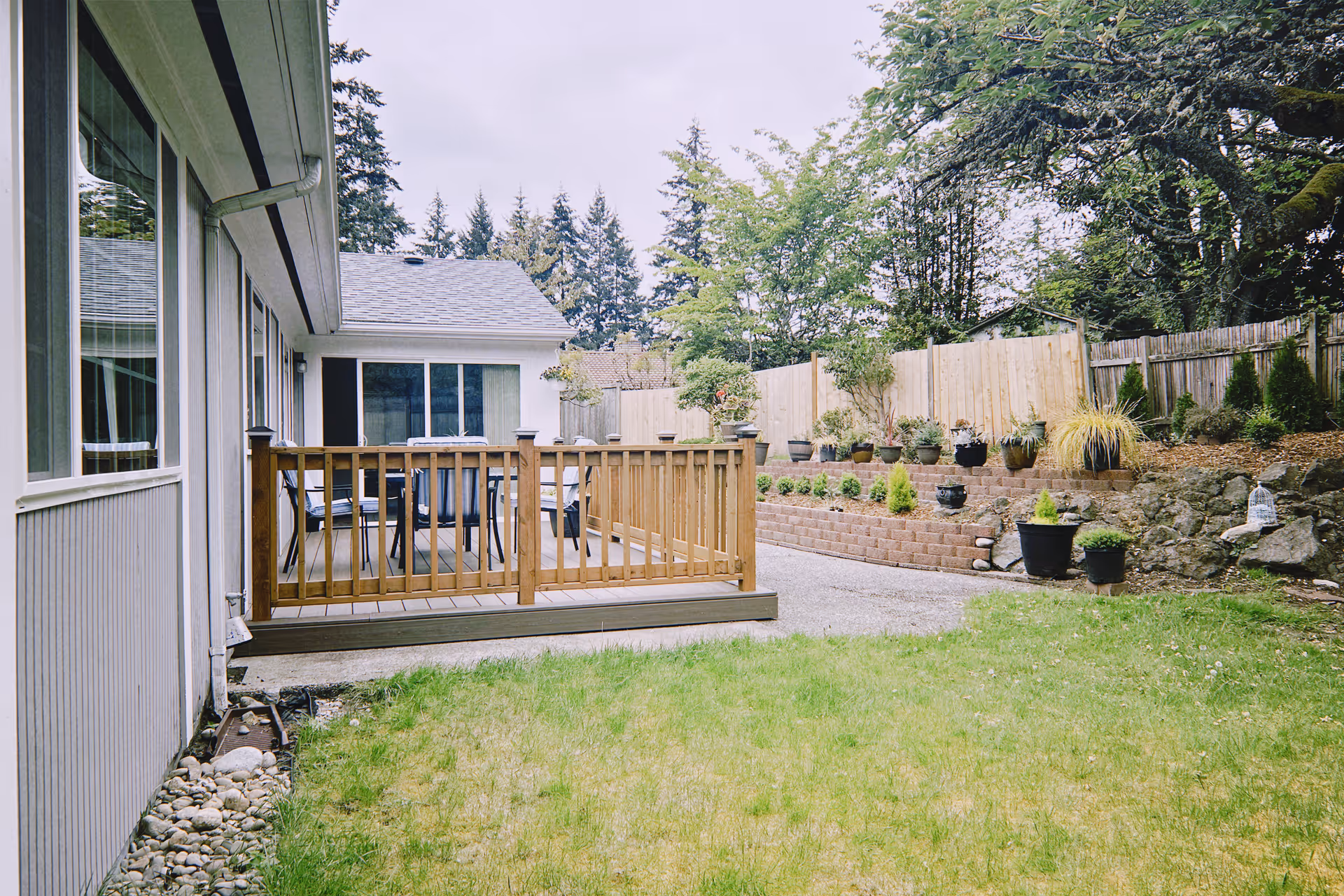 Exterior view of Peace Bridge Adult Family Home with wooden deck, outdoor seating, and potted plants.