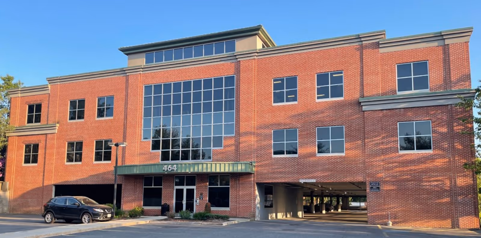 Brick senior living facility exterior with large windows and a covered entrance.