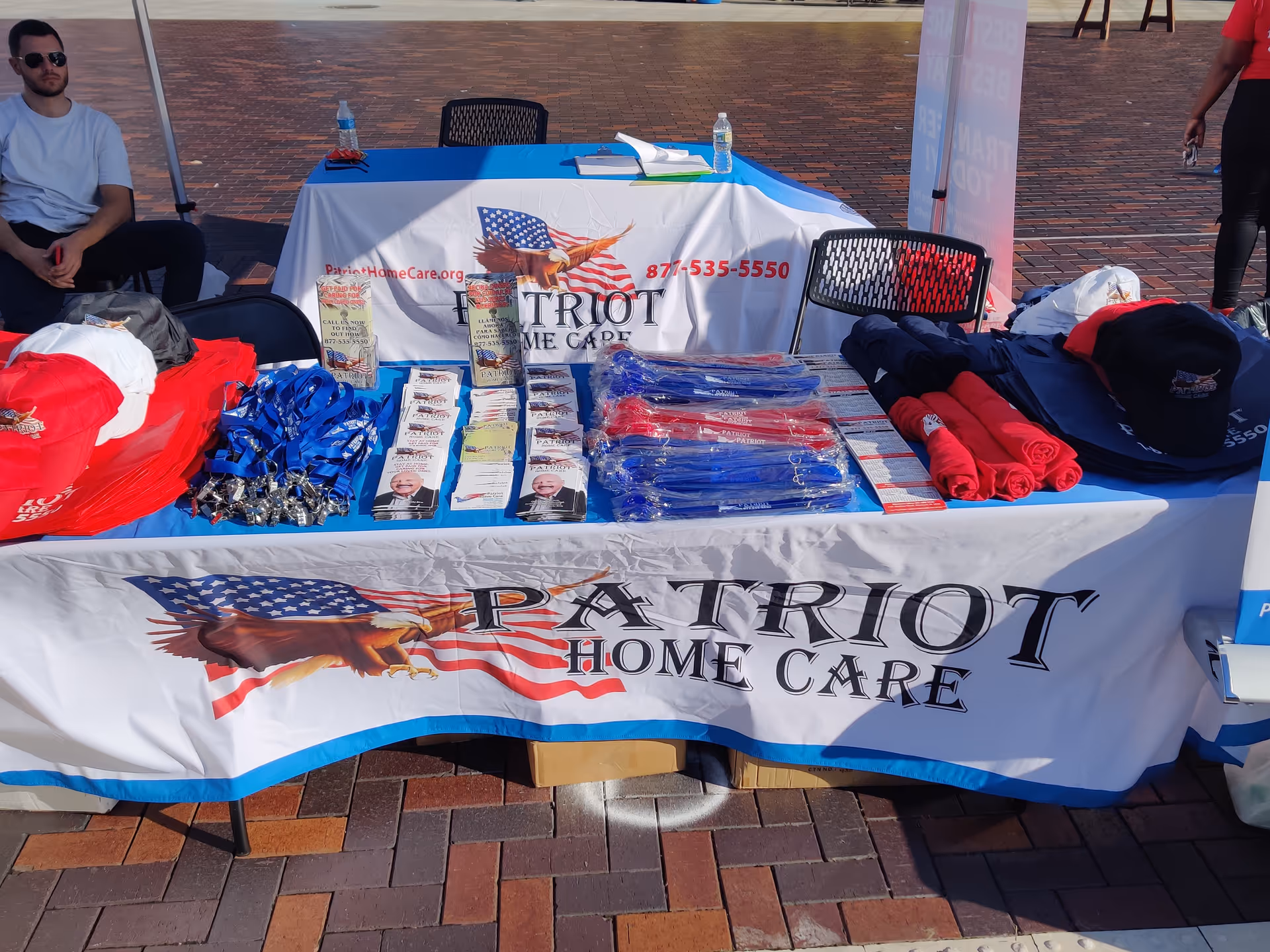 Outdoor Patriot Home Care Allentown booth with banners and promotional materials on a table.