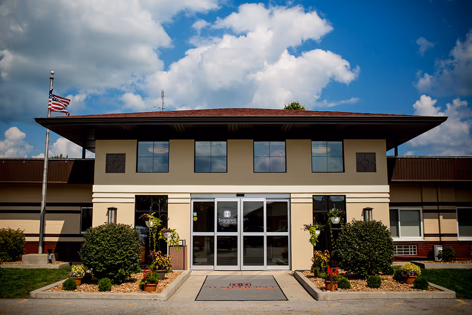 Front view of Lincoln Village Healthcare Center entrance with glass doors and landscaping.