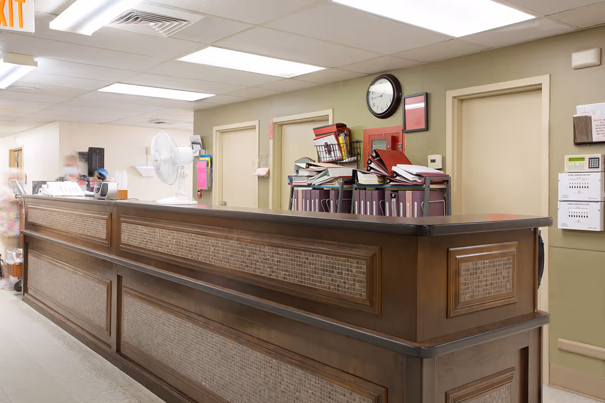 Heritage Hall Dillwyn lobby reception desk with papers and a wall clock.