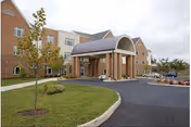Exterior of Dogwood Village-Orange County, a brick senior living building with curved entry canopy.
