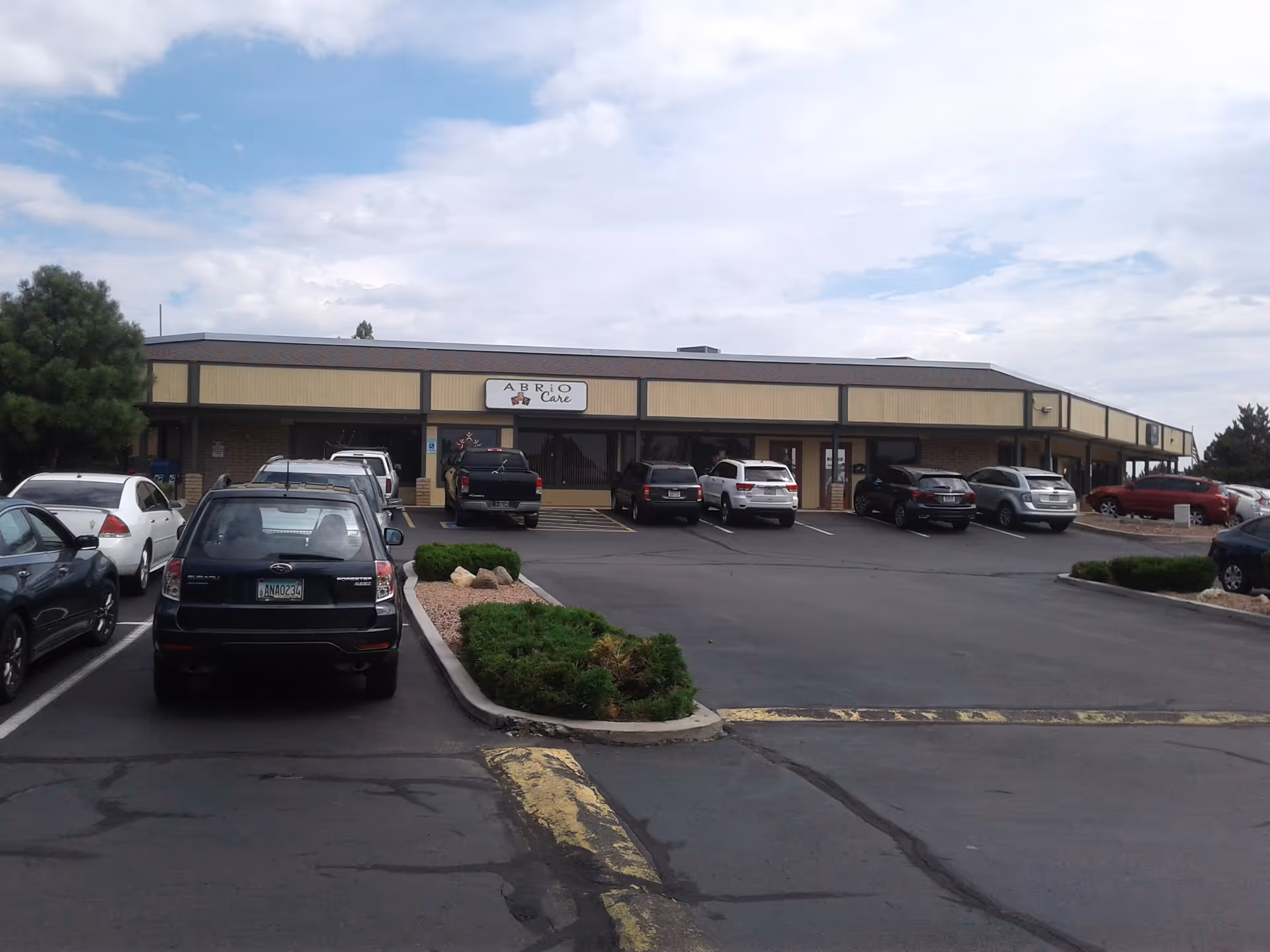 Exterior view of Abrio Home Care facility with a parking lot in front.