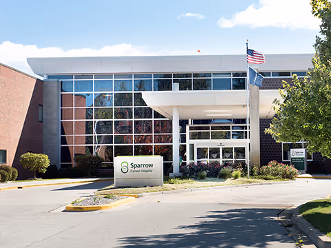 Sparrow Carson Hospital exterior with glass front, entrance canopy, and flag.