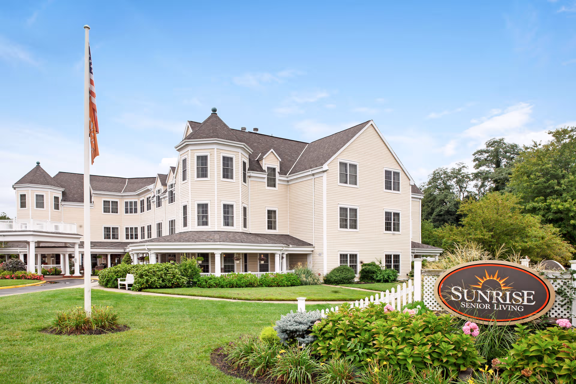 Exterior view of Sunrise Senior Living facility with manicured grounds and sign.