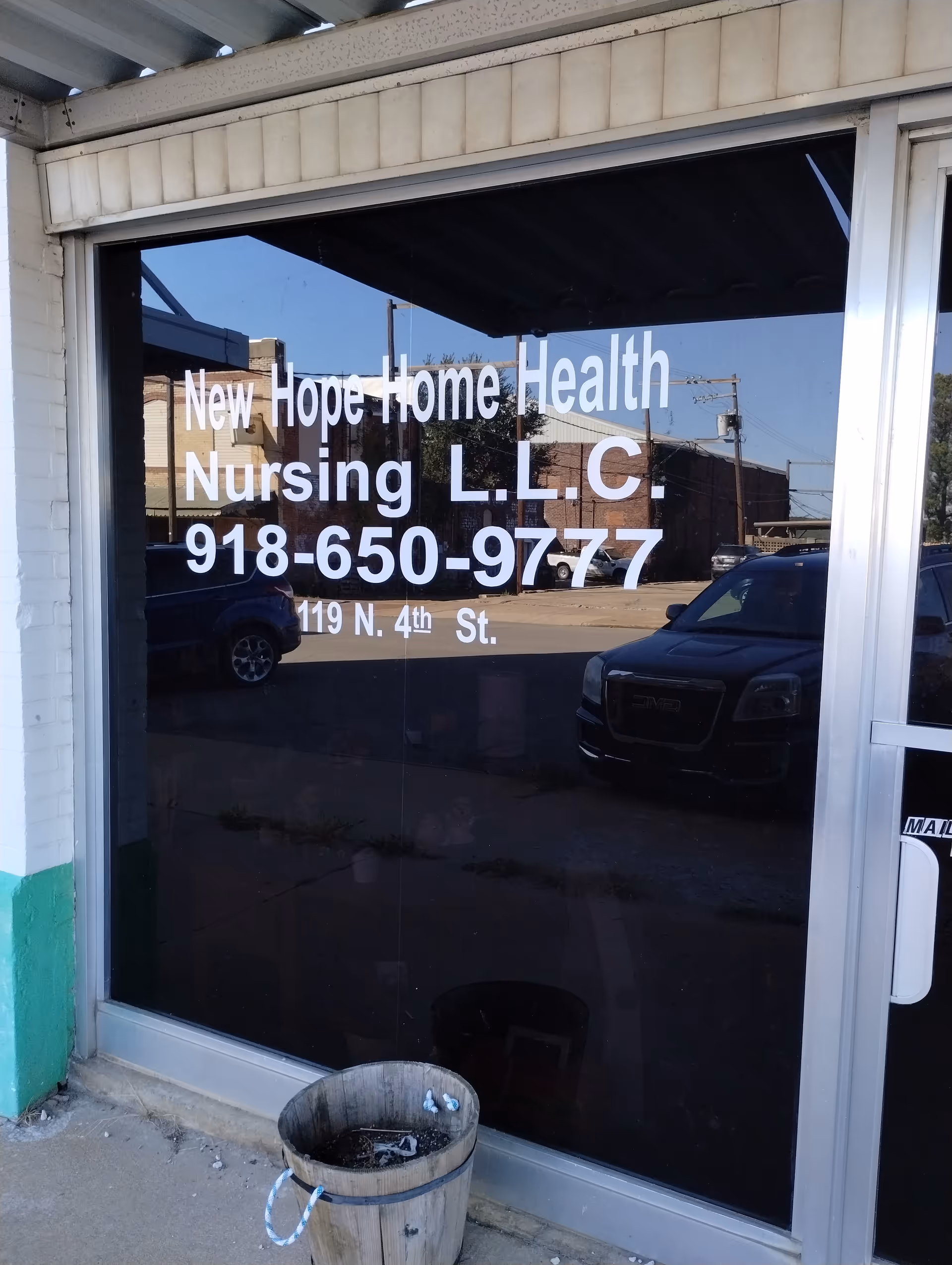 Storefront window of New Hope Home Health Nursing LLC displaying phone number and address.