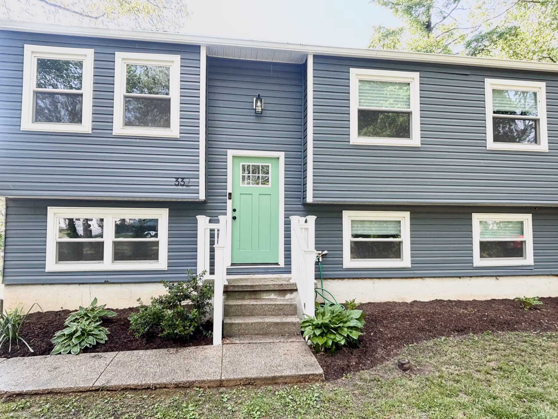 Blue two-story building exterior with a green front door and white trim.