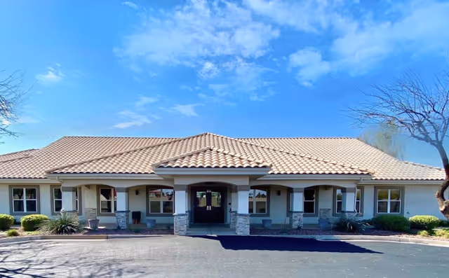 Front view of Fairmont Village senior living building with tiled roof and entrance columns.