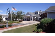 Front view of a senior living facility entrance with a canopy and flag.